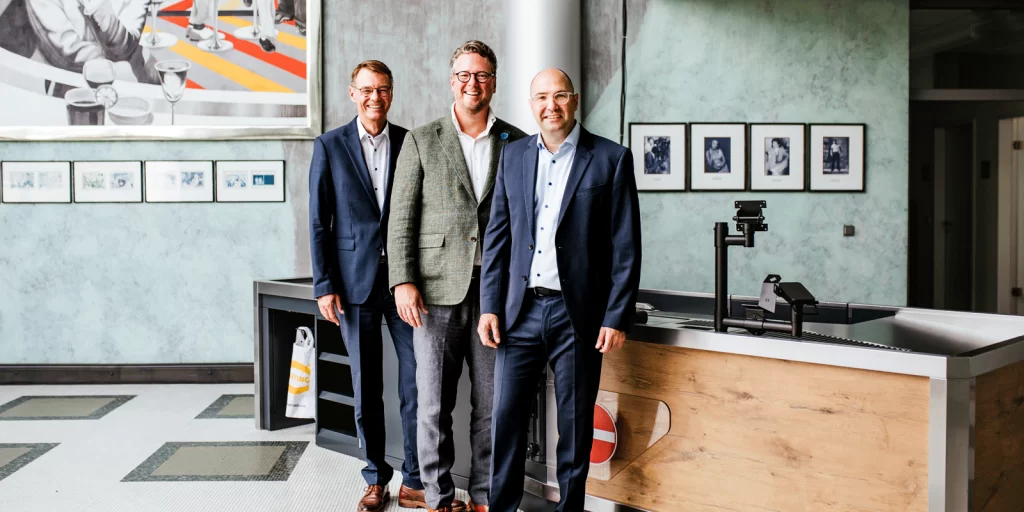 Peter Weichert, Managing Director HARTING Systems, Philip Harting, CEO HARTING Technology Group and Dr Christoph Barth, designated Managing Director of the new HARTING Systems GmbH (f. l.) in front of one of the checkout zones produced by HARTING Systems.